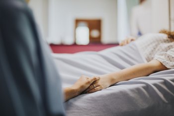 Nurse holding her patients hand
